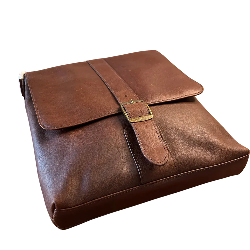 Angled view of brown leather compact messenger bag with front flap