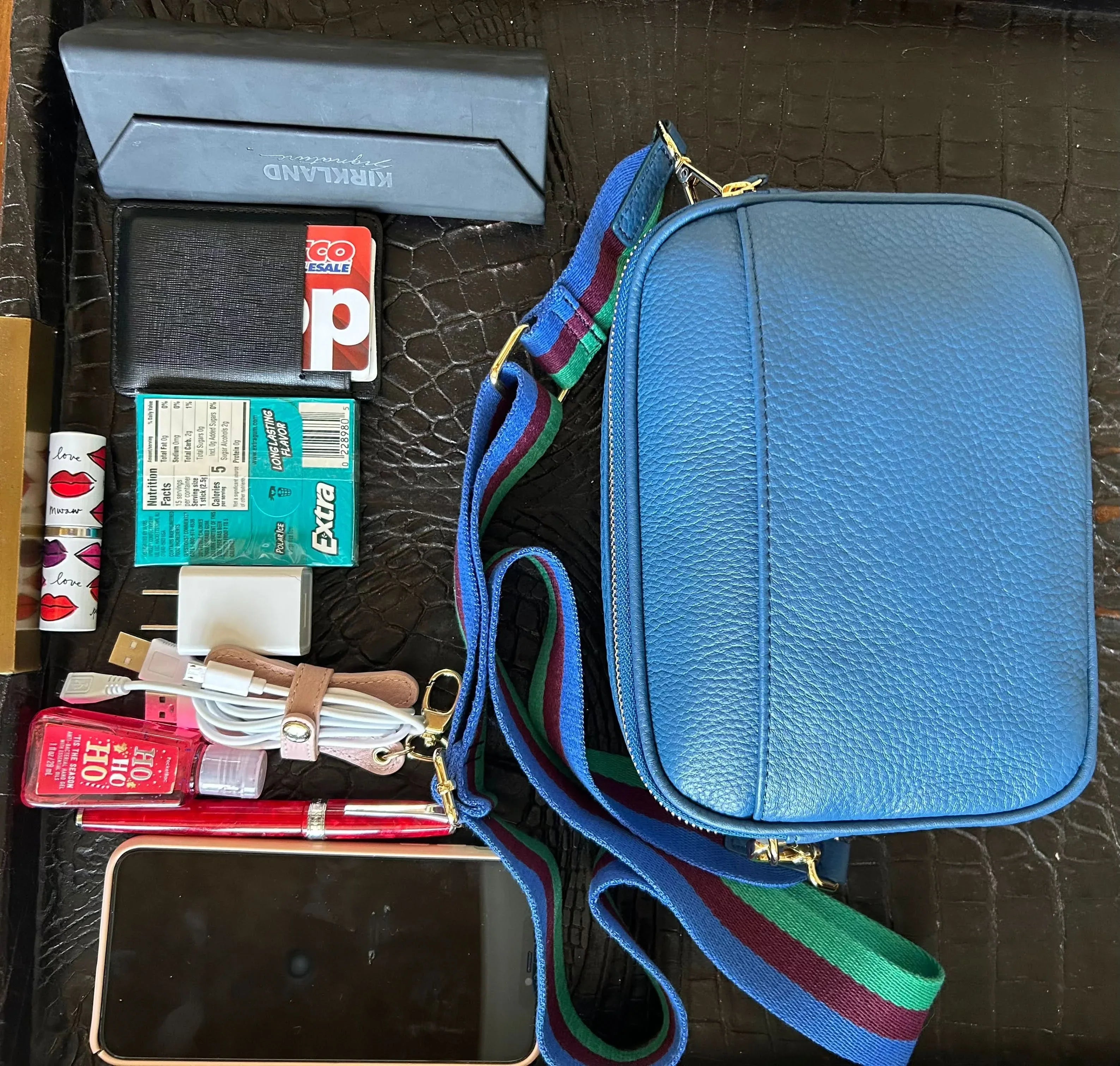 Blue Sophia leather crossbody bag packed in travel luggage