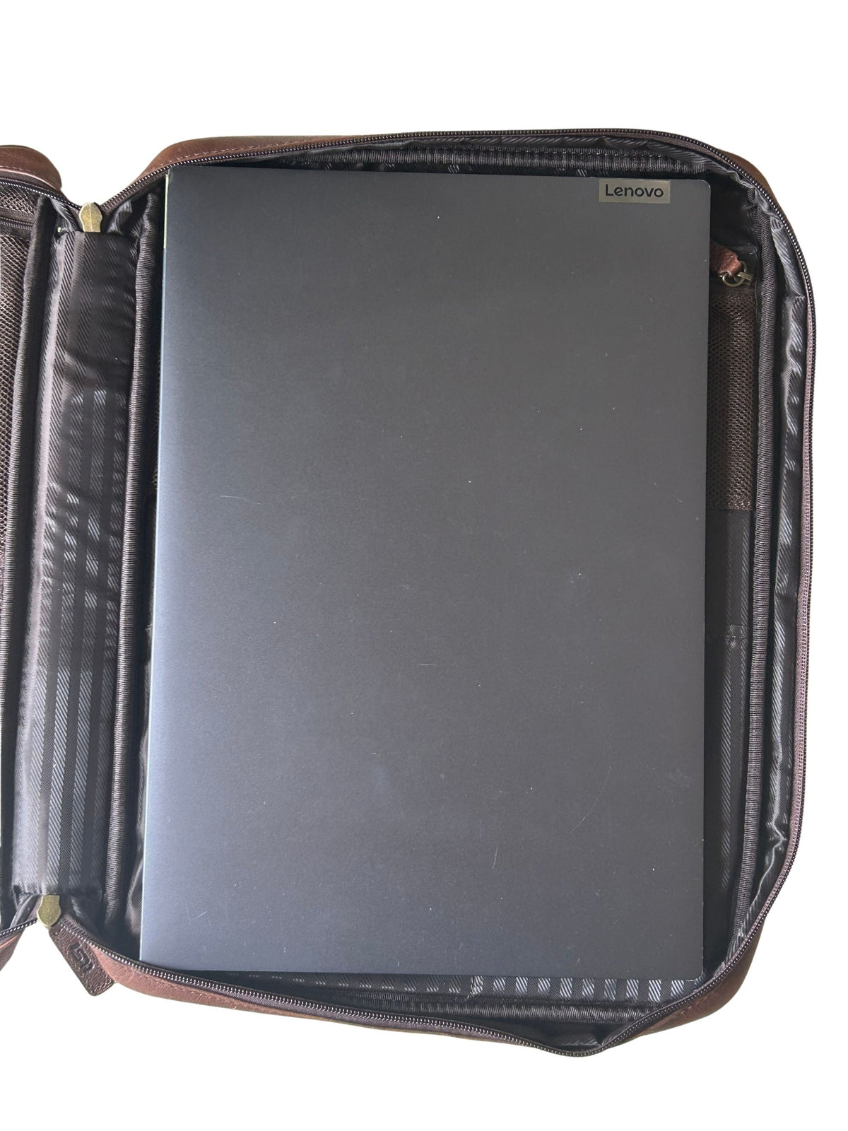 Cambridge full-grain leather laptop tech case shown fitting a 16-inch Lenovo laptop for size reference