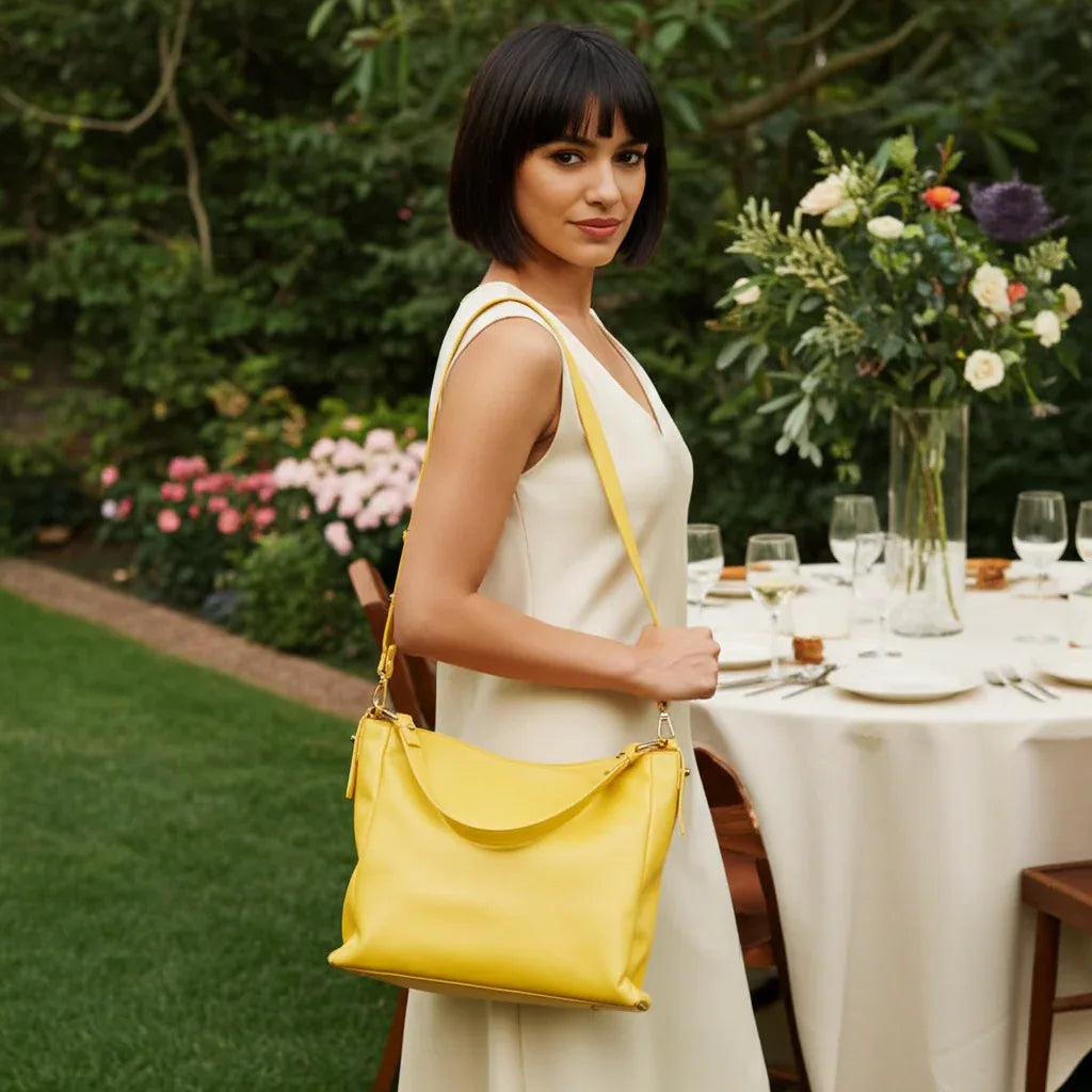 Woman wearing yellow Sophia full-grain leather hobo bag as a shoulder bag